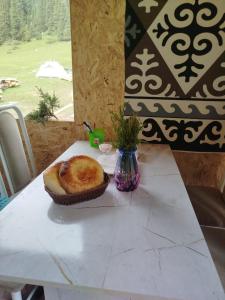 a table with a pastry in a basket on it at Kyrgyz Yurt Camp in Mineralʼnyy Istochnik Altyn-Arasan +35 photos
