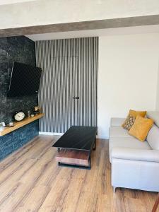 ein Wohnzimmer mit Sofa und Couchtisch in der Unterkunft Apartman Evelissima Brčko in Brčko