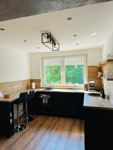 eine Küche mit Arbeitsplatte und Fenster in der Unterkunft Apartman Evelissima Brčko in Brčko