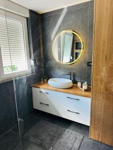 ein Badezimmer mit Waschbecken und Spiegel in der Unterkunft Apartman Evelissima Brčko in Brčko