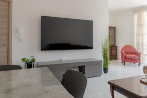 a living room with a television on a white wall at Three Bedroom Qormi Home in Santa Venera