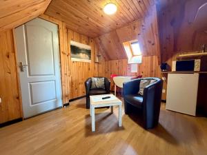 a room with two chairs and a table and a door at Le chant des oiseaux chambre pour deux à quelques minutes de la Baie de Somme entre nature mer et télétravail in Nibas