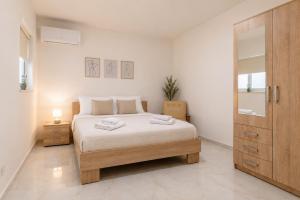 a bedroom with a bed and a wooden door at Three Bedroom Qormi Home in Santa Venera