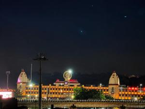 a large building with a ferris wheel on top at night at Hotel City Palace in Varanasi