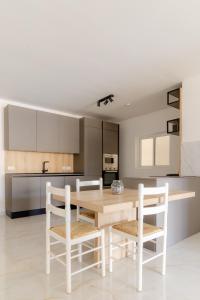 a kitchen with a wooden table and chairs at Three Bedroom Qormi Home in Santa Venera