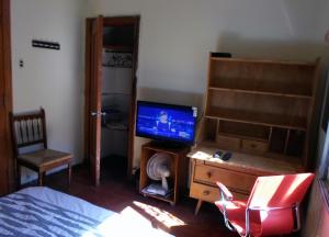 a bedroom with a television and a desk with a chair at Pascua 2-baño compartido in Santiago