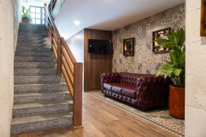 a living room with a couch and a staircase at Gran Vila Nai Boutique Hotel in Guadalajara