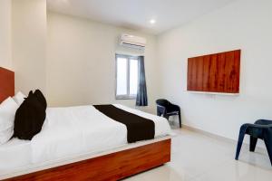 a bedroom with a bed and a tv on the wall at Super Hotel O RB Classic Inn in Kottapalli