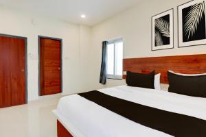 a bedroom with a large bed in a room at Super Hotel O RB Classic Inn in Kottapalli