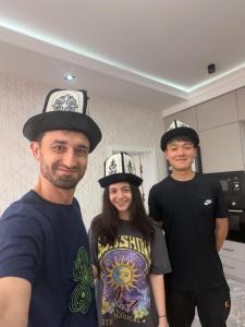 three people wearing hats standing in a kitchen at Rest House in Bokonbayevo