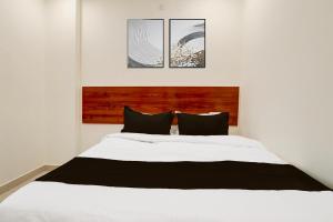 a bedroom with a large white bed with two pillows at Super Hotel O RB Classic Inn in Kottapalli +21 photos