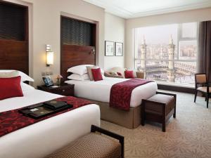 a hotel room with two beds and a large window at Makkah Clock Royal Tower, A Fairmont Hotel in Mecca