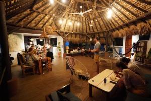 a group of people sitting at tables in a restaurant at Punta Dreams in Brisas de Zicatela