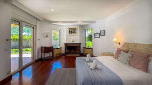a bedroom with a large bed and a fireplace at Villa Terramar by Hello Homes Sitges in Sitges +109 photos