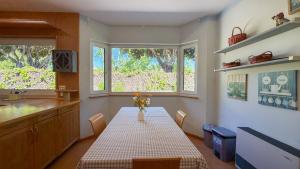 a kitchen with a table and two windows and a counter at Villa Terramar by Hello Homes Sitges in Sitges