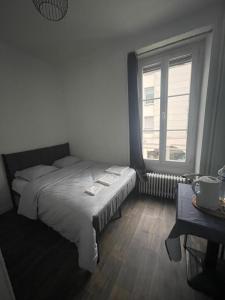 a bedroom with a bed and a large window at Hôtel Du Mans in Angers