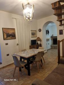 a dining room table with chairs and a chandelier at Casale Montanari in Matigge
