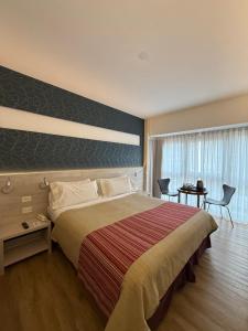 a hotel room with a large bed and a table at Regente Palace Hotel in Buenos Aires