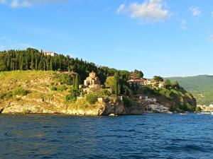 a house on a rocky island in the water at Travel Hub Hostel Social and Friendly in Ohrid