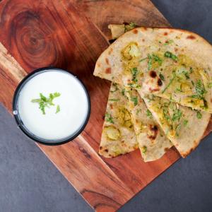 a cutting board with two slices of pizza and a bowl of sauce at Hotel City Palace in Varanasi