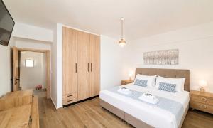 a bedroom with a large white bed with blue pillows at Georgioupolis Blue Villa in Georgioupolis
