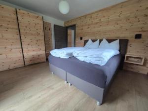 a bedroom with a bed in a room with wooden walls at Urlauben im Grünen in Fuschl am See