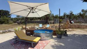 a patio with a table and an umbrella and chairs at La Mia Lamia in Cisternino