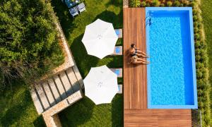 an overhead view of a pool with two umbrellas at Georgioupolis Blue Villa in Georgioupolis
