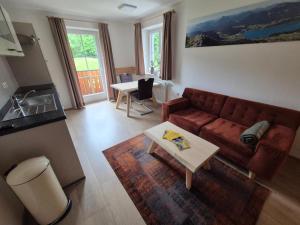 a living room with a couch and a table at Urlauben im Grünen in Fuschl am See