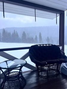 a room with a couch and a chair in front of a window at Лайт Хайс Буковель in Palyanytsya