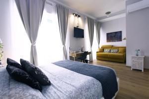 a bedroom with a bed and a yellow couch at La Dolce Vita Civitavecchia in Civitavecchia
