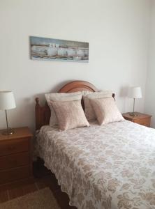 a bedroom with a bed with two night stands and two lamps at Casa Afonso Guesthouse in Ferrel
