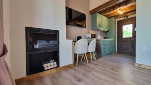 a kitchen with a fireplace and a kitchen with green cabinets at Stone Loft in Karpenisi +35 photos