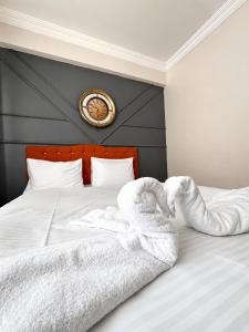 a bed with white sheets and towels on it at Bolu novara suit in Bolu