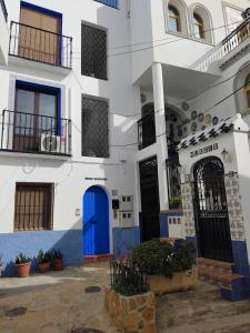 a white building with blue doors and windows at Casa Karim in Mojácar