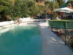 a large pool of blue water next to a house at Cabaña Cala Blanca II in Málaga