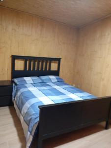 a bedroom with a bed with a blue and white blanket at Cabaña Cala Blanca II in Málaga