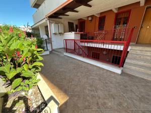 un portico di una casa con una recinzione rossa di Regina34 a Torre a Mare