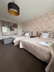 a bedroom with two beds and a wall with a picture at Dworek in Szonowice +73 photos