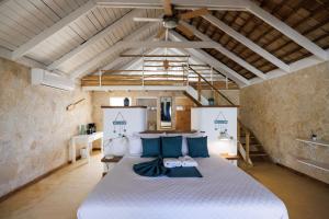 a bedroom with a large bed with blue pillows at El Mosquito Boutique Hotel Playa Bonita in Las Terrenas +158 photos