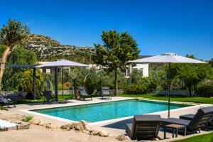 a swimming pool with lawn chairs and umbrellas at AVENTINE - Luxury Residences with Private Pools in Kalithies +115 photos