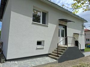 a white house with stairs and a window at Ubytovanie u Aničky in Nová Sedlica