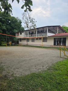 a building with a volleyball court in front of it at Finca la santa in San Luis de Cubarral