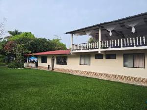 a house with a lawn in front of it at Finca la santa in San Luis de Cubarral