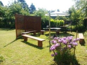 a park with two benches and a table and flowers at Pokoje Augustów 5 osobowy i 3 osobowy in Augustów