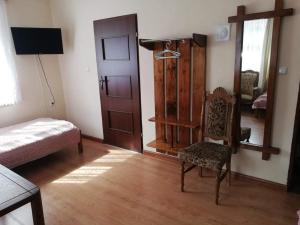 a room with a bed and a chair and a door at Pokoje Augustów 5 osobowy i 3 osobowy in Augustów