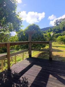 a wooden bench sitting on top of a wooden deck at Pousada Pindobas in Venda Nova do Imigrante