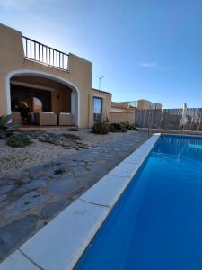 a swimming pool in front of a house at Casa Logos Stintino - Private pool in Stintino