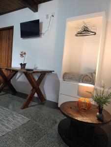 a room with a desk and a table and a bed at Pousada Pindobas in Venda Nova do Imigrante