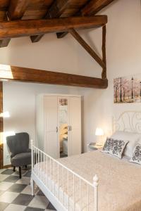 a bedroom with a white bed and a chair at La casa di Mariasole in SantʼElpidio a Mare
